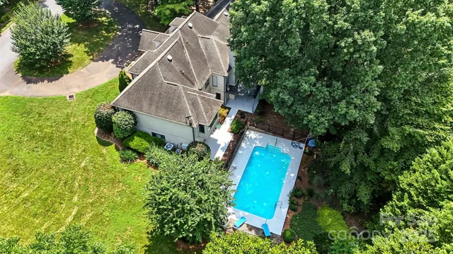 a view of a house with pool and chairs