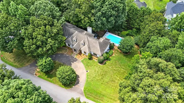 an aerial view of residential houses with outdoor space and trees