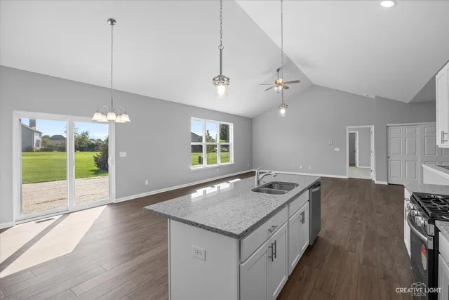 a kitchen with a stove a faucet a chandelier and wooden floor