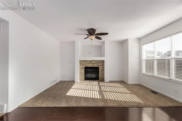 an empty room with a fireplace and windows
