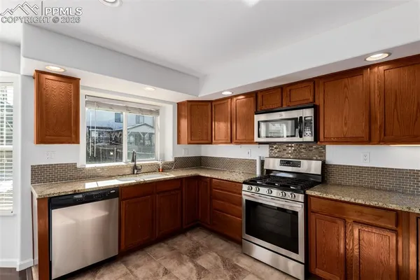 a kitchen with stainless steel appliances granite countertop a sink stove and refrigerator