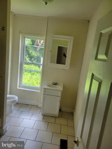 a bathroom with a sink a toilet and a window