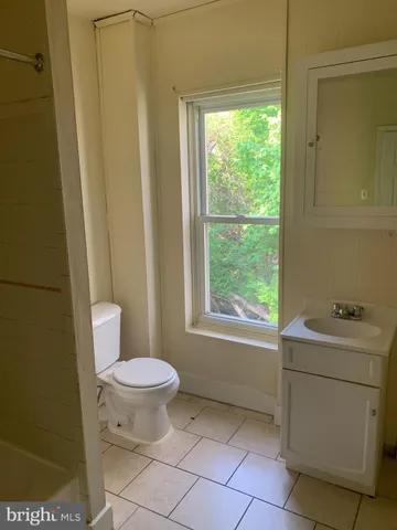 a bathroom with a sink toilet and window