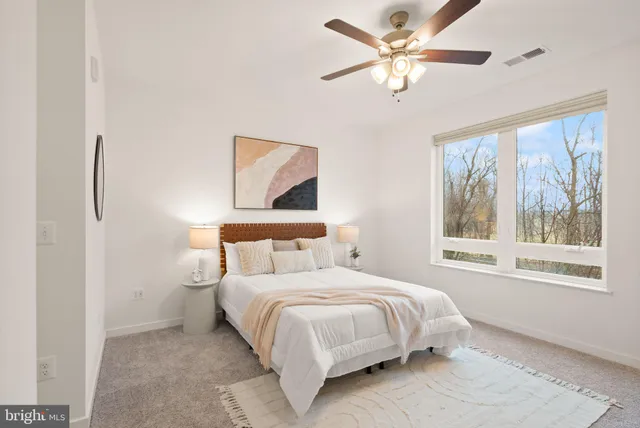 a bedroom with a bed and a large window