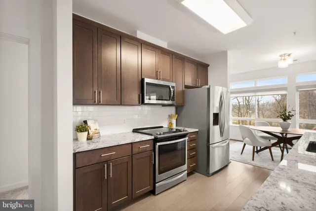 a kitchen with stainless steel appliances granite countertop a refrigerator stove microwave and sink