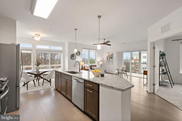 a kitchen with lots of counter space a sink appliances and living room view