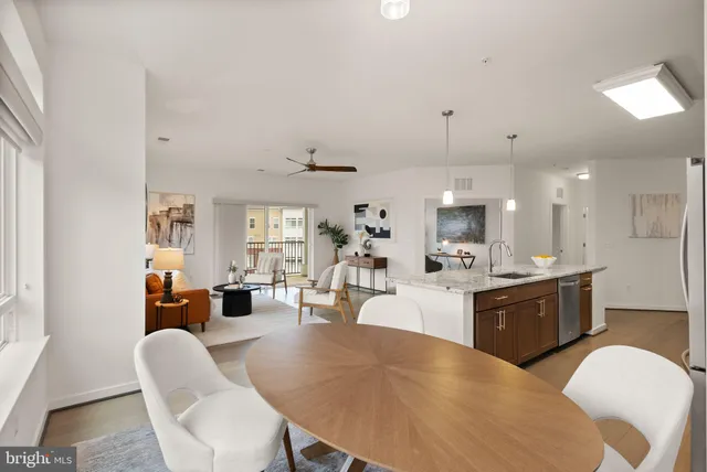 a large white kitchen with lots of counter space dining table and chairs