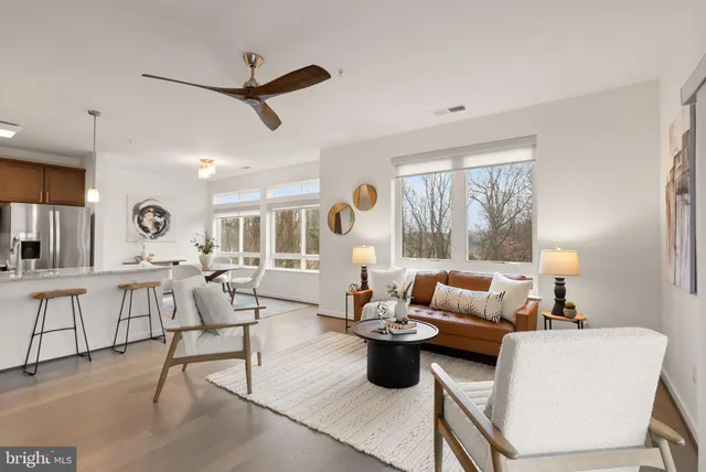 a living room with furniture a fireplace and a large window