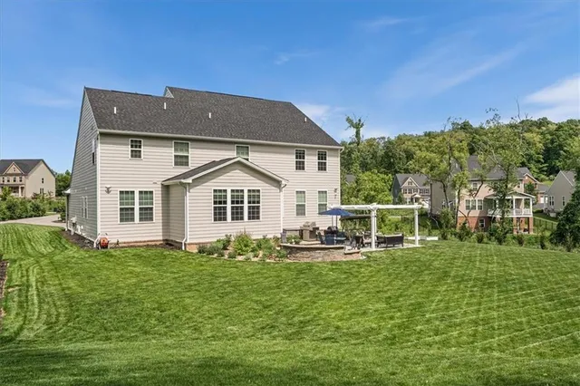 a white house with a big yard and more trees