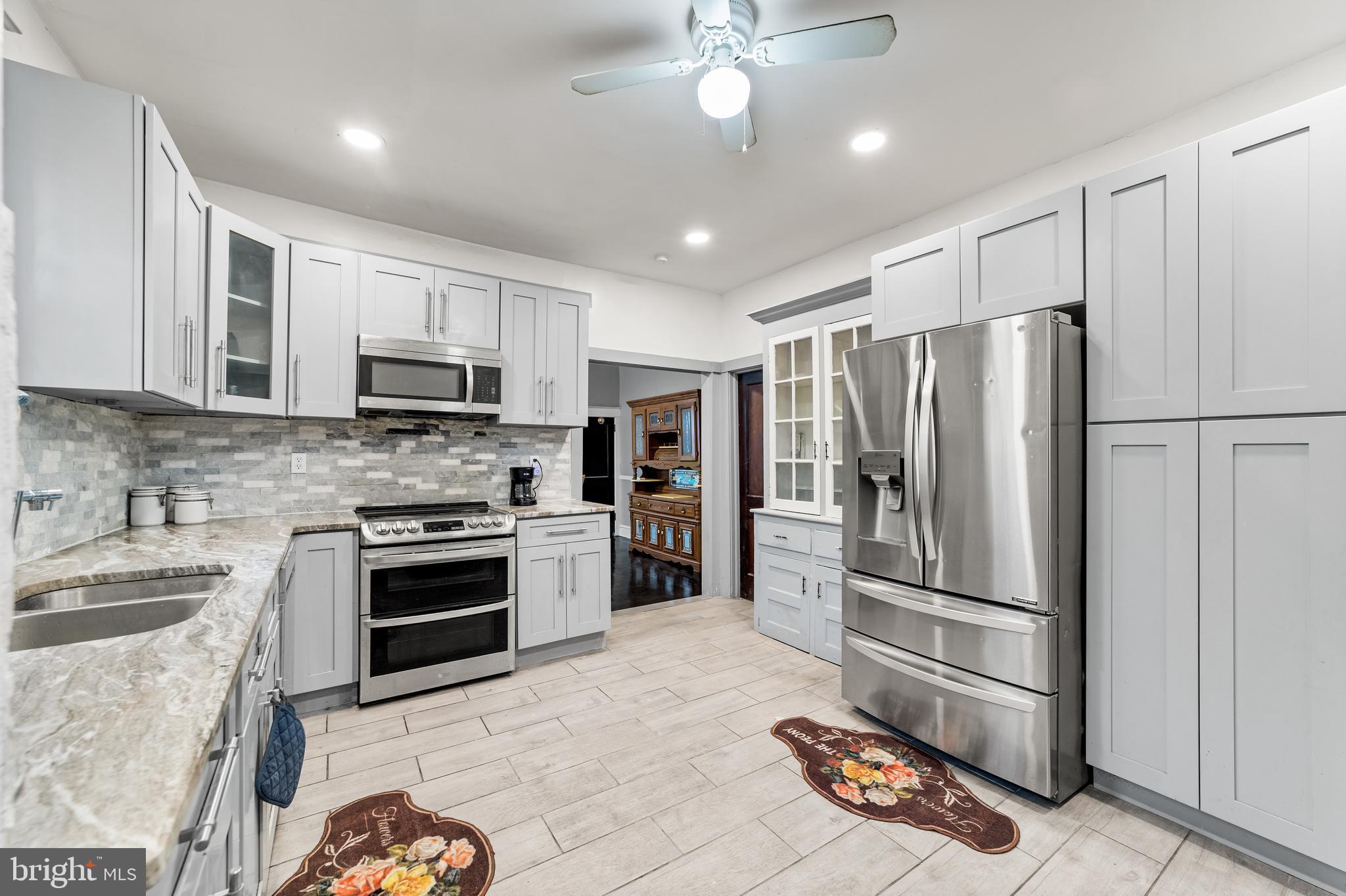 a kitchen with granite countertop a refrigerator oven and a sink