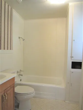 a bathroom with a granite countertop toilet a sink and bathtub