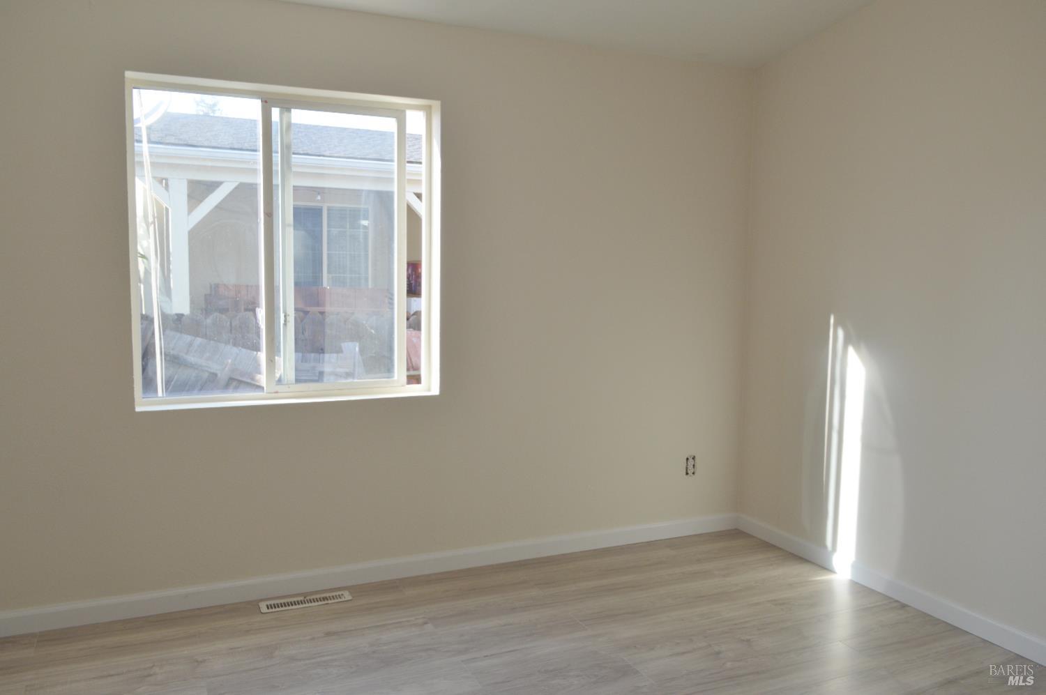 3900 North State Street, Unit 75 Ukiah, CA 95482 - Photo 20 of 22 an empty room with wooden floor and windows