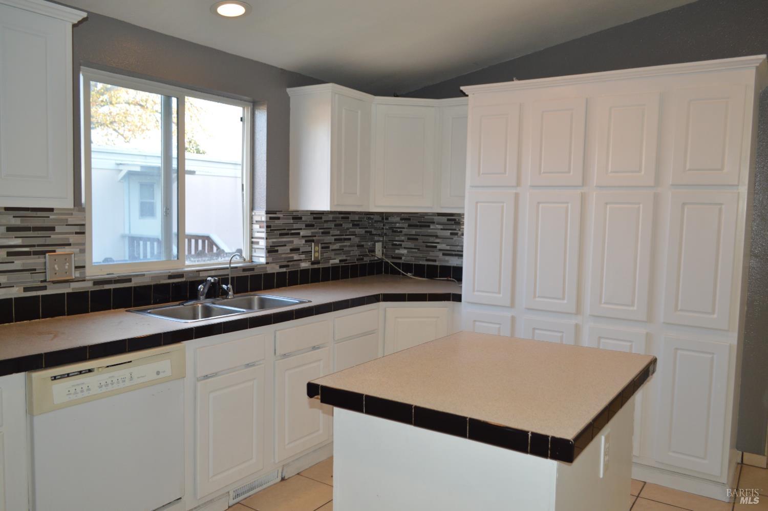 3900 North State Street, Unit 75 Ukiah, CA 95482 - Photo 4 of 22 a kitchen with a sink dishwasher and white cabinets with wooden floor