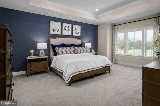 a bedroom with a bed a couch and a large window