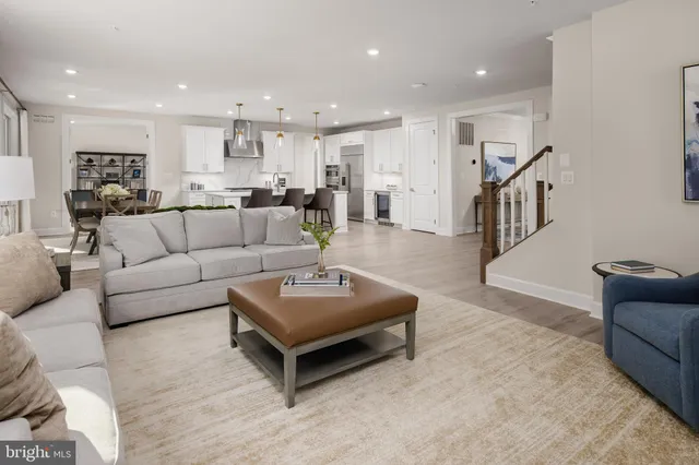 a living room with furniture and a view of kitchen