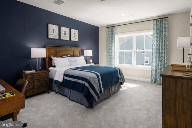 a spacious bedroom with a bed and wooden floor