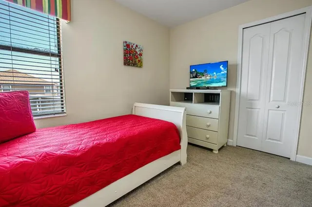 a bedroom with a bed and a flat screen tv