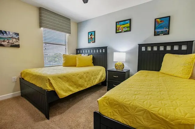 a bedroom with two beds and painting on the wall