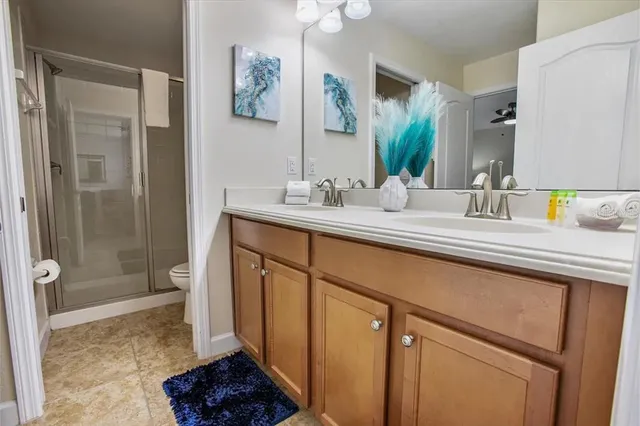 a bathroom with a sink a toilet and shower