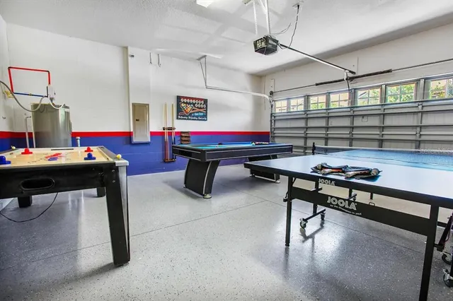 a view of a white building with a large pool and a large tree