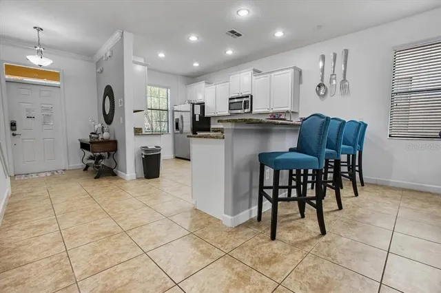 a kitchen with stainless steel appliances kitchen island granite countertop a refrigerator and cabinets