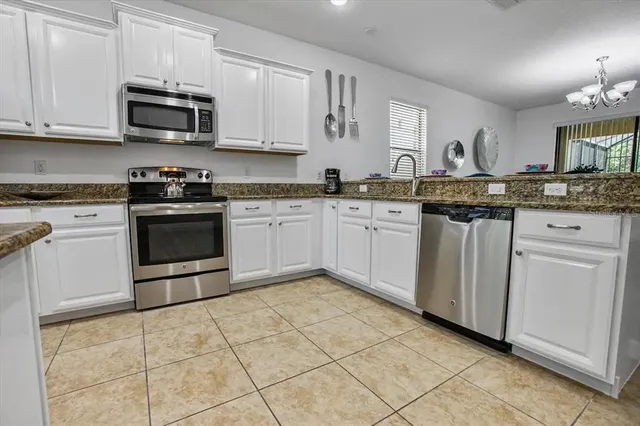 a kitchen with stainless steel appliances granite countertop a stove sink and cabinets