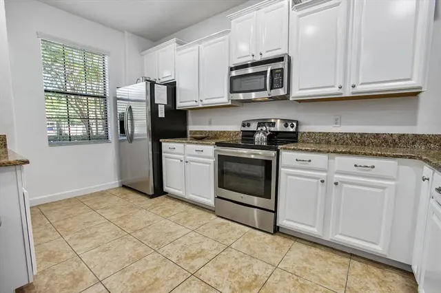 a kitchen with stainless steel appliances granite countertop a stove a sink and a microwave