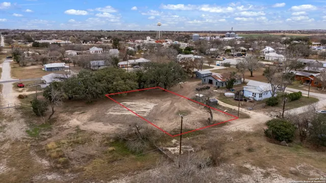 an aerial view of a house with a yard and lake view