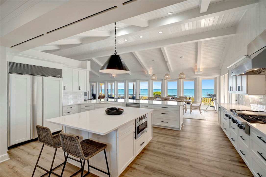 176 Ocean Way Vero Beach, FL 32963 - Photo 12 of 36 a kitchen with a stove a chandelier and wooden floor