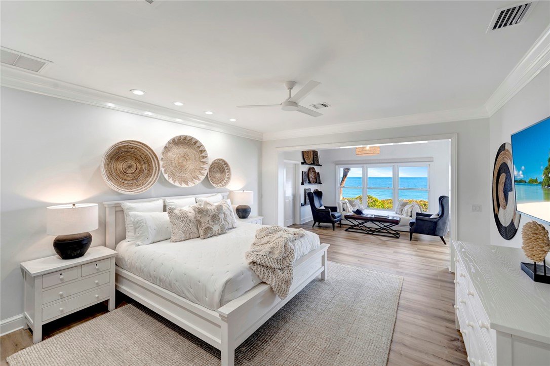 176 Ocean Way Vero Beach, FL 32963 - Photo 15 of 36 a bedroom with a bed a mirror and a large window