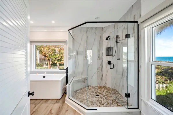 a bathroom with a tub a sink and a shower