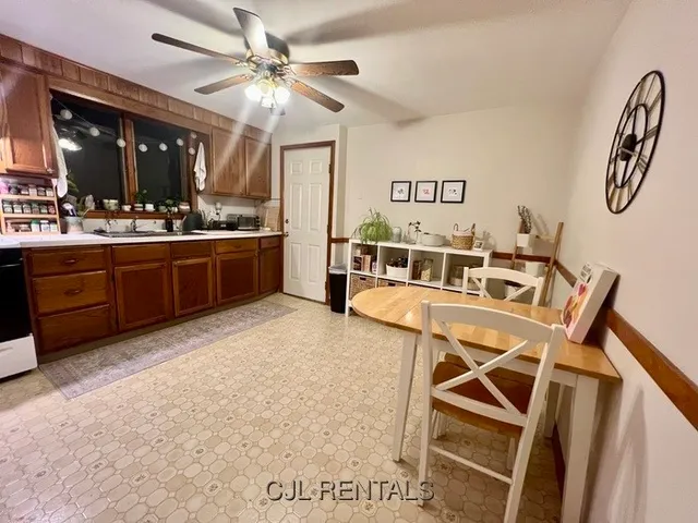 a living room with granite countertop furniture a ceiling fan and a wooden floor
