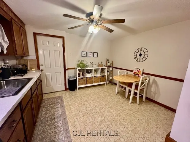 a view of a kitchen with furniture and a ceiling fan