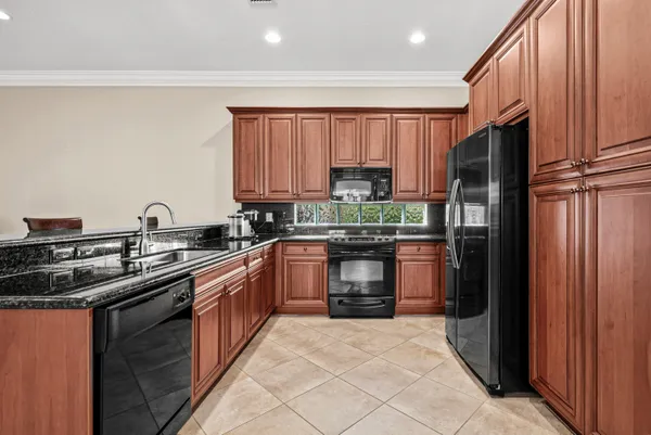 a kitchen with stainless steel appliances granite countertop a refrigerator and a sink