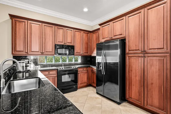 a kitchen with stainless steel appliances granite countertop a refrigerator stove and sink