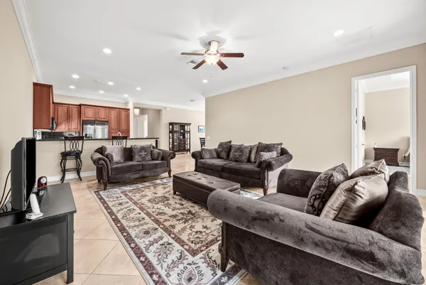 a living room with furniture kitchen view and a chandelier