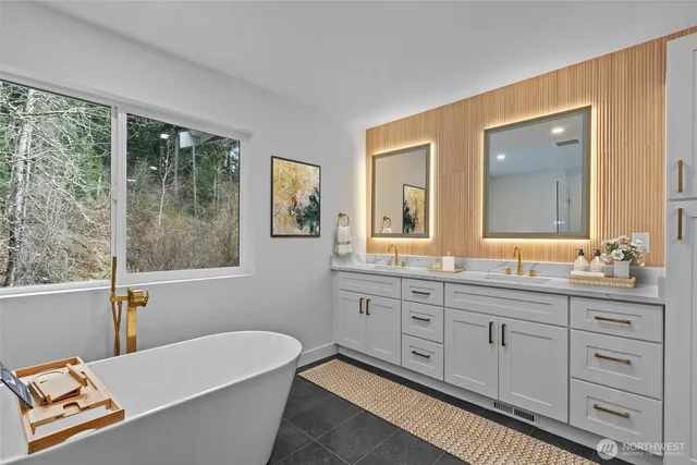 a spacious bathroom with a tub double sink window and mirror