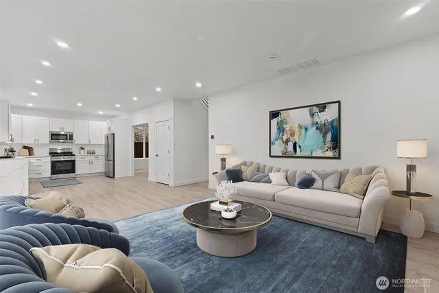 a living room with furniture and a view of kitchen