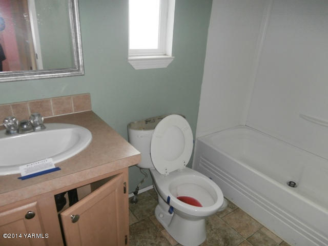 11305 Gilbert Road Yakima, WA 98903 - Photo 6 of 35 a bathroom with a toilet a sink and a window