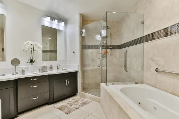 a bathroom with a tub sink shower and mirror