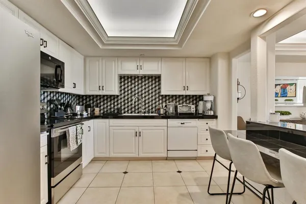 a kitchen with granite countertop white cabinets and white appliances