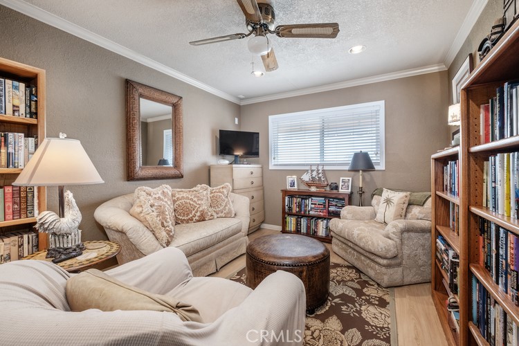 9331 Cape Cod Drive Huntington Beach, CA 92646 - Photo 21 of 31 a living room with furniture lots of books and a window
