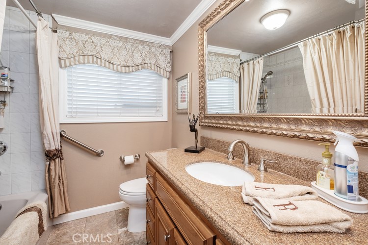 9331 Cape Cod Drive Huntington Beach, CA 92646 - Photo 23 of 31 a bathroom with a granite countertop sink and a mirror