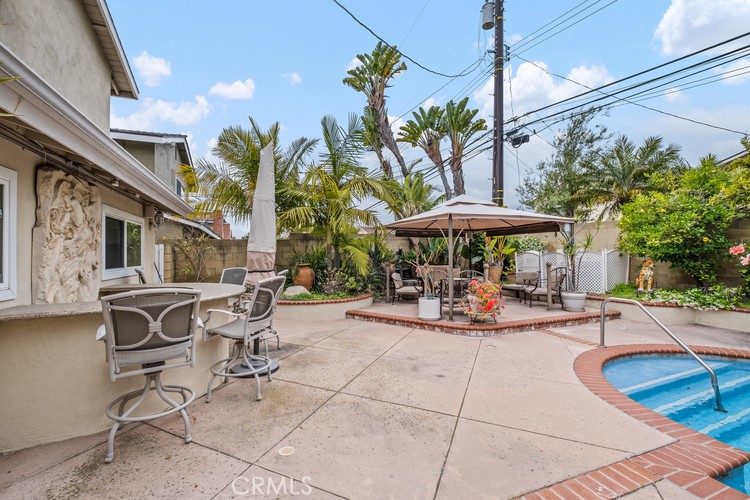 9331 Cape Cod Drive Huntington Beach, CA 92646 - Photo 28 of 31 a view of a patio with a table and chairs under an umbrella