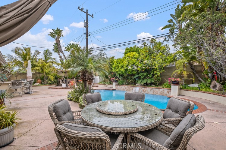 9331 Cape Cod Drive Huntington Beach, CA 92646 - Photo 29 of 31 a view of a patio with table and chairs potted plants