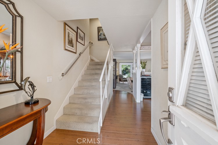 9331 Cape Cod Drive Huntington Beach, CA 92646 - Photo 3 of 31 a view of a hallway with wooden floor and staircase