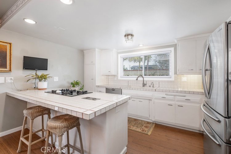 9331 Cape Cod Drive Huntington Beach, CA 92646 - Photo 6 of 31 a kitchen with a sink stove and refrigerator