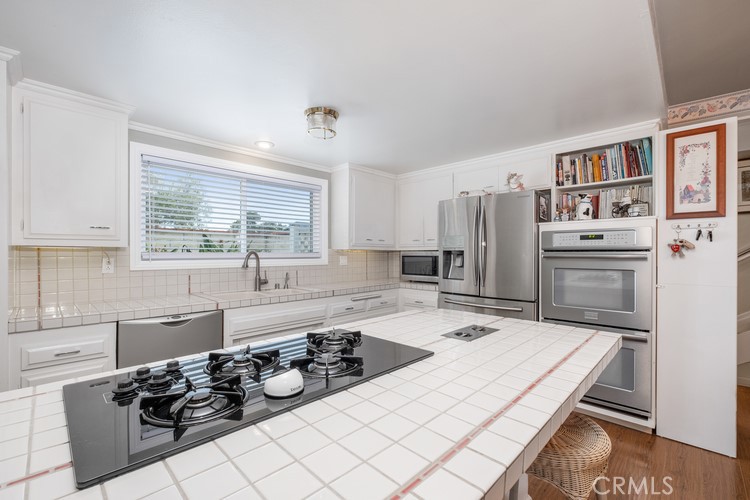 9331 Cape Cod Drive Huntington Beach, CA 92646 - Photo 7 of 31 a kitchen with a sink stove and refrigerator