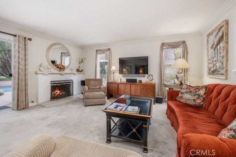 9331 Cape Cod Drive Huntington Beach, CA 92646 - Photo 9 of 31 a living room with furniture a flat screen tv and a fireplace
