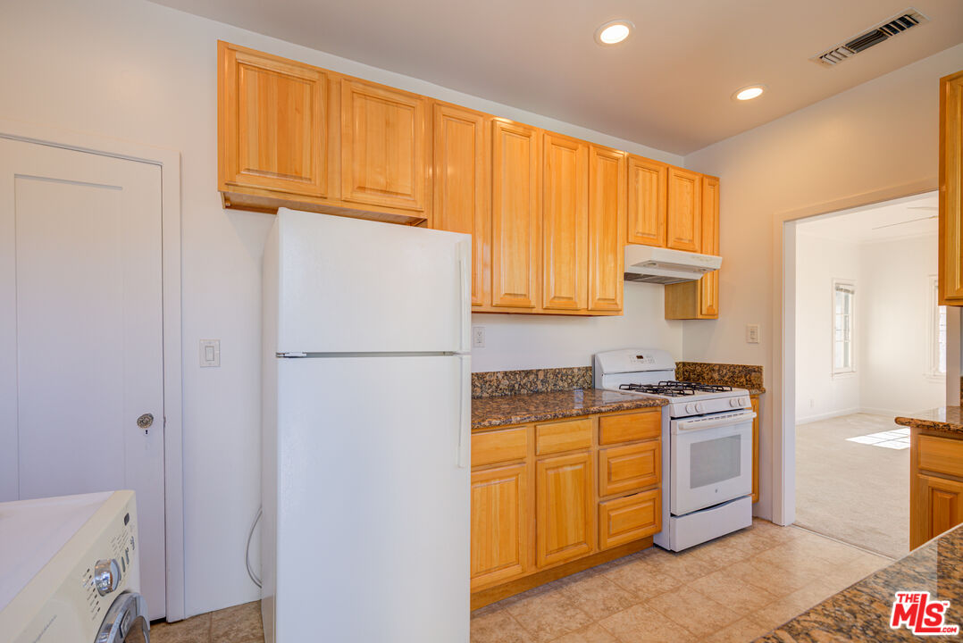 1447 North Vista Street, Unit 1/2 Los Angeles, CA 90046 - Photo 16 of 23 a kitchen with stainless steel appliances granite countertop a refrigerator a stove a sink dishwasher and wooden cabinets